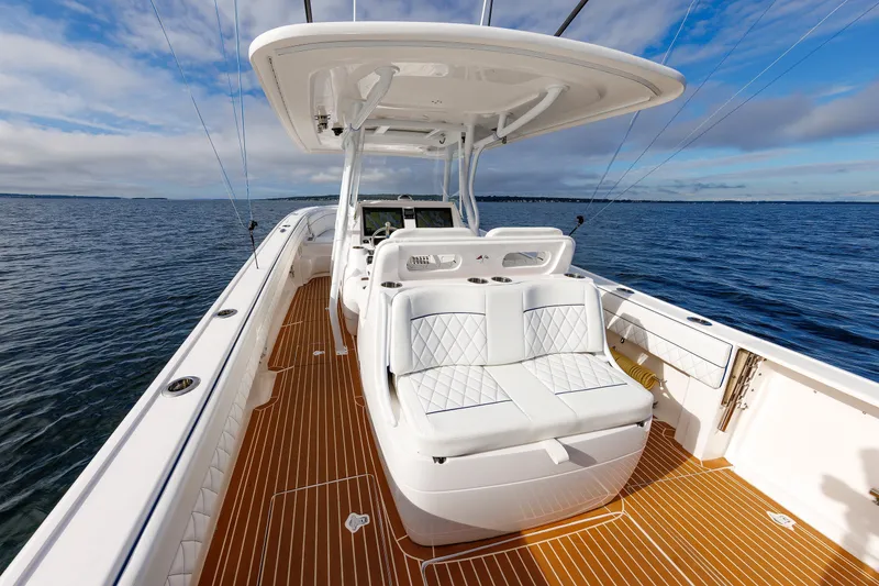 Slide: The Image of 2017 Intrepid 375 Nomad FE boat with white seating and wooden deck on open water. - 40