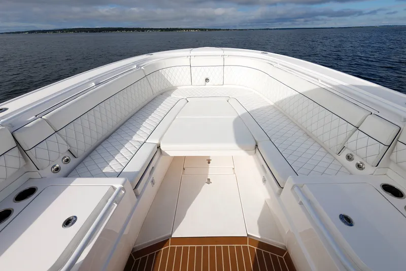 Slide: The Image of 2017 Intrepid 375 Nomad FE boat interior with white seating and ocean view. - 54
