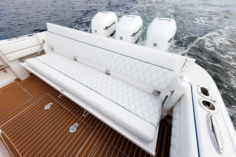 Slide: The Image of 2017 Intrepid 375 Nomad FE boat with white seating and triple outboard engines. - 38