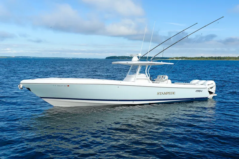 Slide: The Image of 2017 Intrepid 375 Nomad FE boat on open water, clear sky, fishing rods visible. - 2
