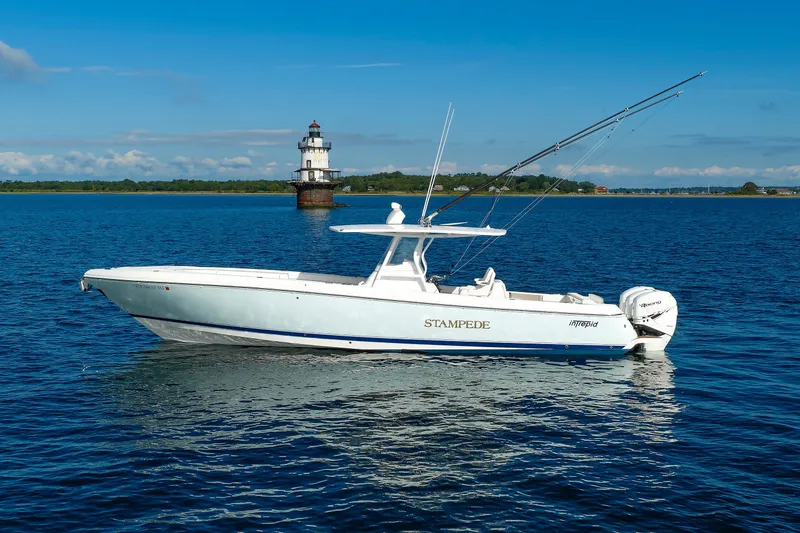 The Image of 2017 Intrepid 375 Nomad FE boat on water near lighthouse under clear blue sky. - 1