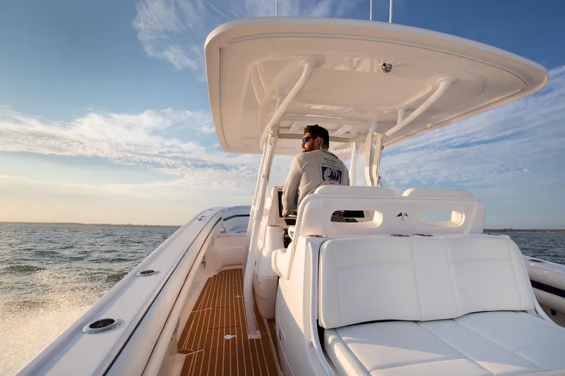 Slide: The Image of Man steering 2017 Intrepid 375 Nomad FE boat on open water under clear sky. - 11