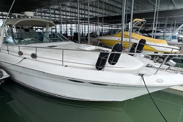 Slide: The Image of 2001 Sea Ray 340 Sundancer docked in a marina, showcasing sleek design and spacious deck. - 2