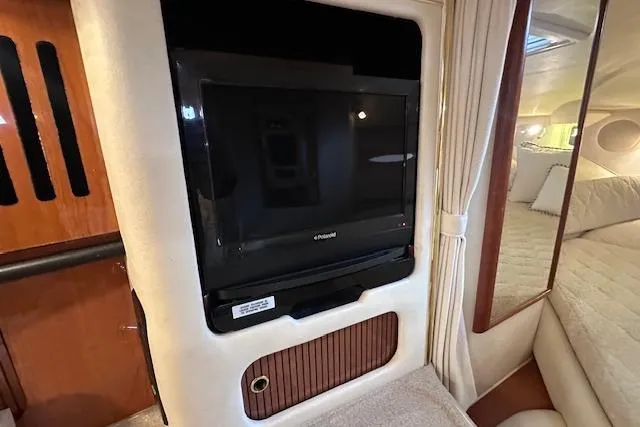 Slide: The Image of Interior of 2001 Sea Ray 340 Sundancer with mounted TV and cozy cabin space. - 23