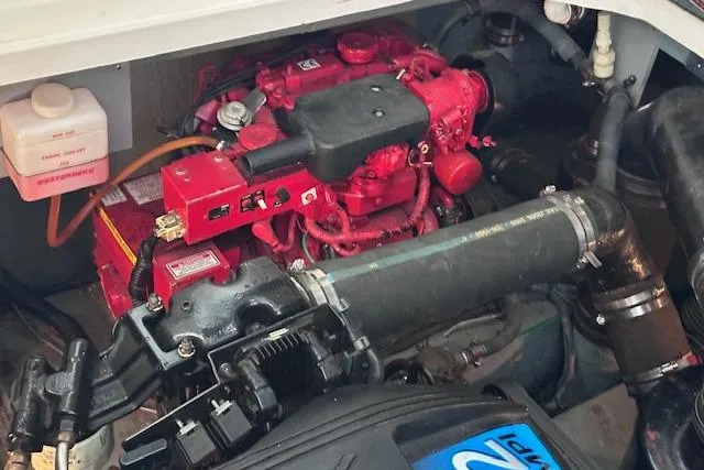 Slide: The Image of Engine compartment of a 2001 Sea Ray 340 Sundancer boat, featuring a red engine. - 26