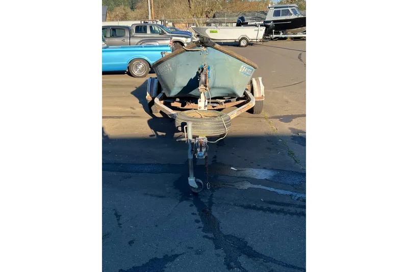 Slide: The Image of 1977 Homebuilt 16' wood boat on trailer, parked in a lot with other vehicles. - 2