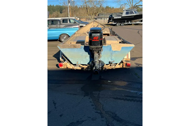 Slide: The Image of 1977 Homebuilt 16' wood boat with outboard motor, parked outdoors. - 3