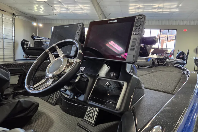 Slide: The Image of 2023 Caymas CX 20 boat dashboard with steering wheel and Lowrance HDS display. - 10