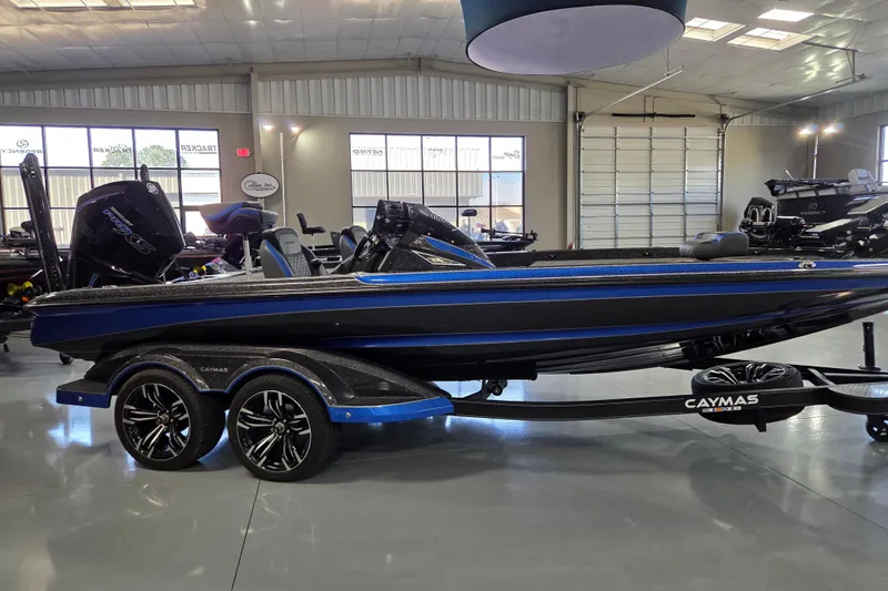 Slide: The Image of 2023 Caymas CX 20 boat in showroom, featuring sleek blue and black design. - 4