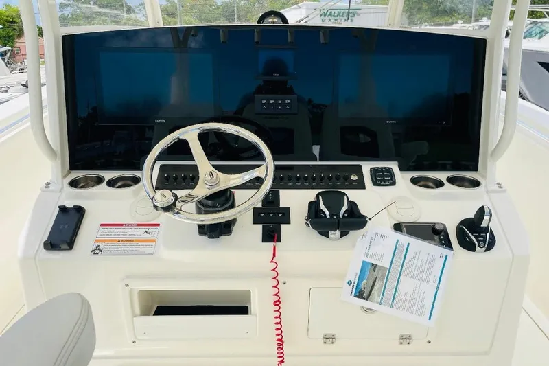 Slide: The Image of 2024 Cobia 350 Center Console helm with steering wheel and navigation controls. - 4