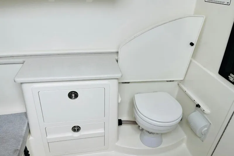Slide: The Image of 2024 Cobia 350 Center Console boat interior with toilet and storage cabinets. - 7