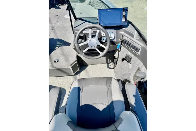 Slide: The Image of 2026 Lund 2075 Impact XS boat cockpit with steering wheel and control panel. - 10