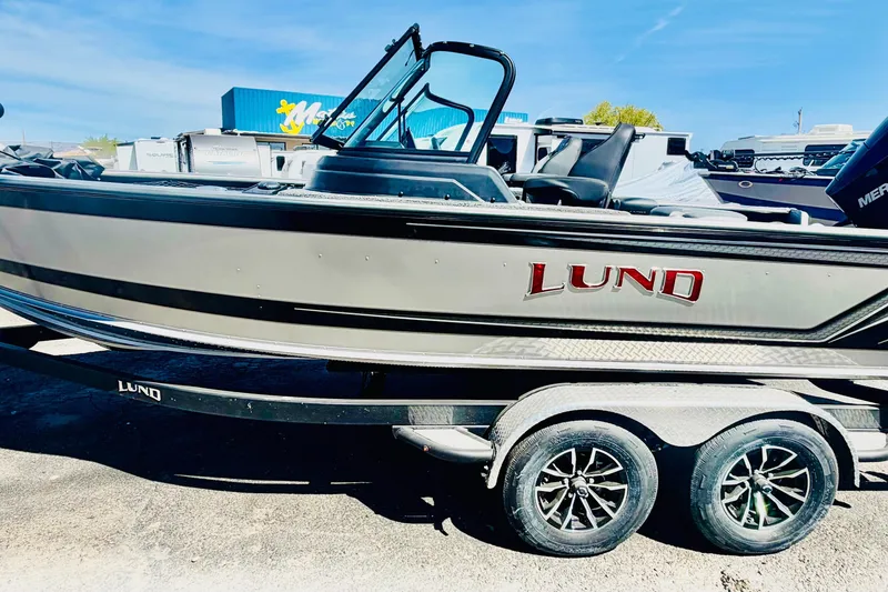 Slide: The Image of 2026 Lund 2075 Impact XS boat on trailer, side view, sunny day. - 2