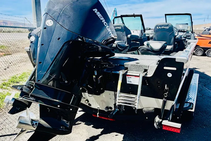 Slide: The Image of 2026 Lund 2075 Impact XS boat with Mercury outboard motor, parked outdoors. - 5