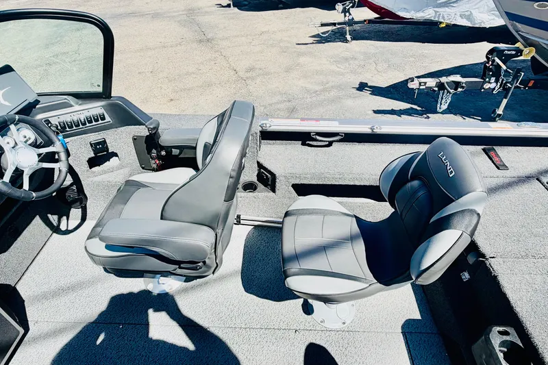 Slide: The Image of 2026 Lund 2075 Impact XS boat interior with two gray seats and steering wheel. - 9
