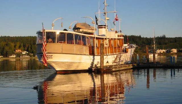 Slide: The Image of 1929 Custom HOFFAR-BEECHING Fantail Yacht docked on calm water at sunset. - 2