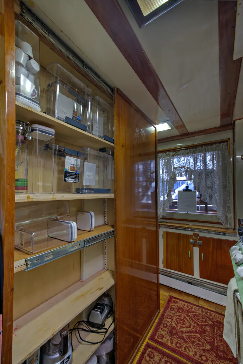 Slide: The Image of 1929 Custom HOFFAR-BEECHING Fantail Yacht interior with wooden shelves and window. - 49