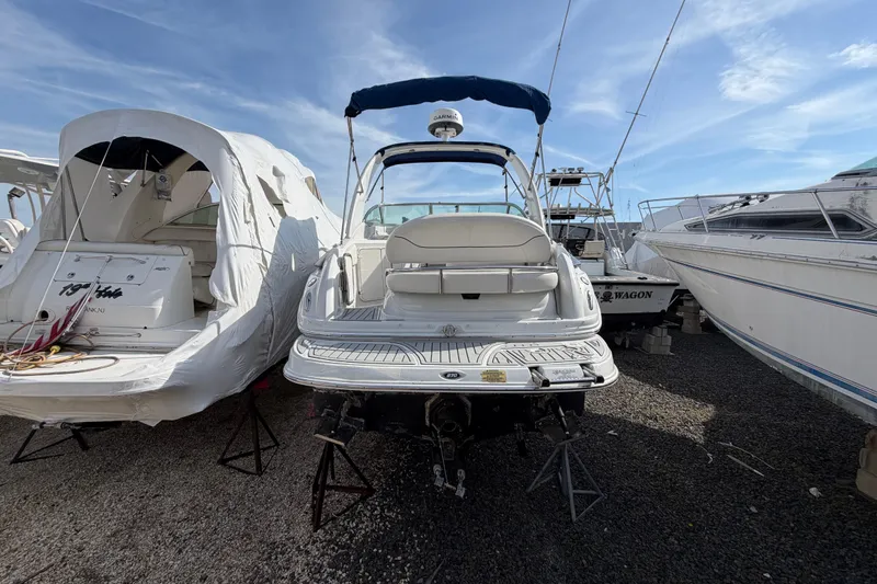 Slide: The Image of 2006 Crownline 270 CR boat in storage, surrounded by other vessels under clear sky. - 5