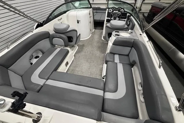 Slide: The Image of 2023 NauticStar 243DC Sport Deck interior with gray cushioned seating and integrated speakers. - 14