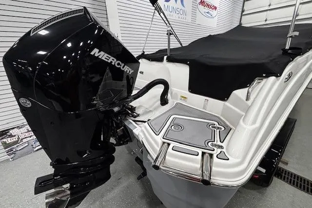 Slide: The Image of 2023 NauticStar 243DC Sport Deck interior with gray seating and carpeted flooring. - 18