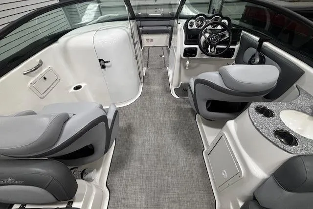 Slide: The Image of 2023 NauticStar 243DC Sport Deck boat in showroom, featuring sleek seating and modern design. - 22
