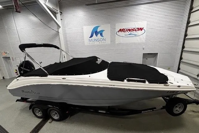 Slide: The Image of 2023 NauticStar 243DC Sport Deck boat with cover, displayed on a trailer. - 28