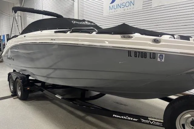 Slide: The Image of 2023 NauticStar 243DC Sport Deck boat on trailer, parked outside dealership. - 3