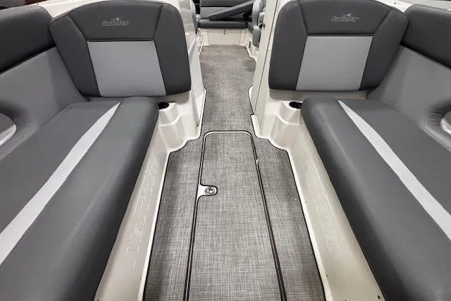 Slide: The Image of 2023 NauticStar 243DC Sport Deck boat with outboard motor, black canopy, and sleek design. - 30