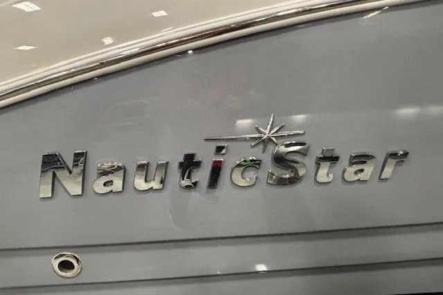 Slide: The Image of 2023 NauticStar 243DC Sport Deck boat with black outboard motor in showroom. - 37