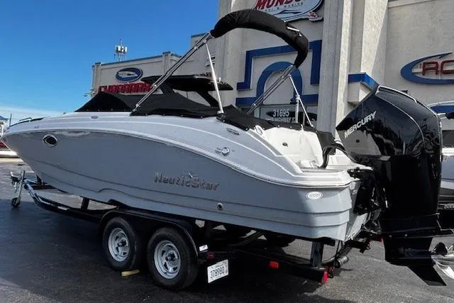 Slide: The Image of Sunset over calm water, highlighting a 2023 NauticStar 243DC Sport Deck boat. - 49