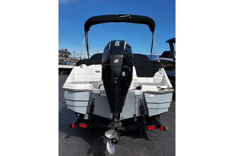 Slide: The Image of 2023 NauticStar 243 DC boat with outboard motor and black canopy, rear view. - 53