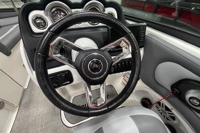 Slide: The Image of 2023 NauticStar 243DC Sport Deck interior with gray cushioned seating and built-in speakers. - 8