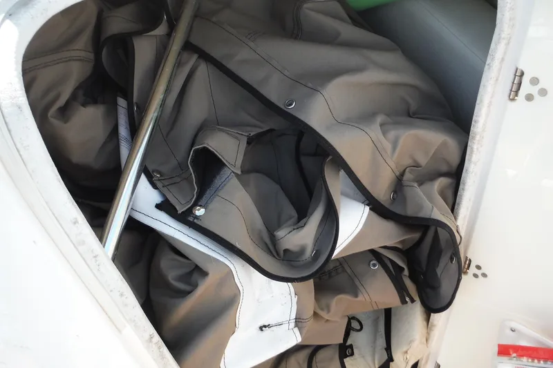 Slide: The Image of Storage compartment of a 2011 Yamaha Boats 242 Limited, containing folded canvas and metal pole. - 20