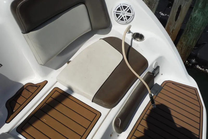 Slide: The Image of 2011 Yamaha Boats 242 Limited seating area with brown and white cushions, speaker, and deck. - 32