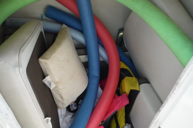 Slide: The Image of Storage compartment of 2011 Yamaha 242 Limited boat with pool noodles and cushions. - 35