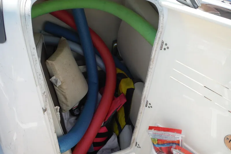 Slide: The Image of Storage compartment of 2011 Yamaha 242 Limited boat with pool noodles and gear. - 36