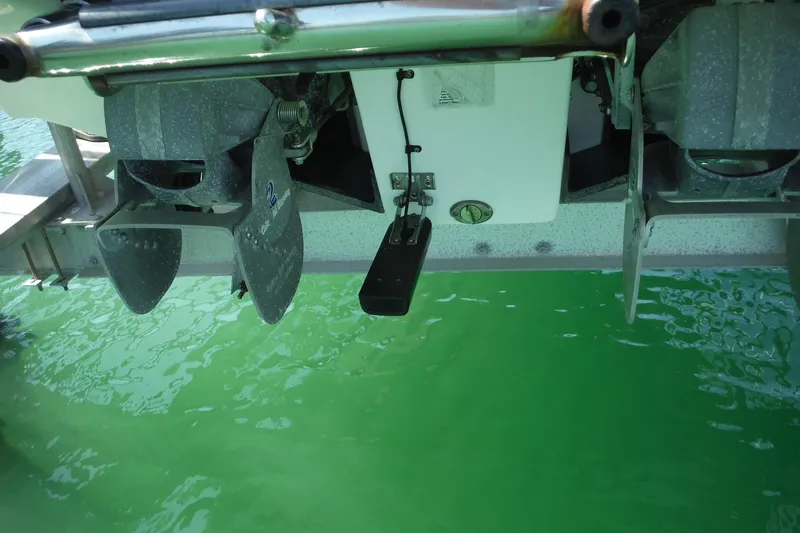 Slide: The Image of Rear view of 2011 Yamaha Boats 242 Limited propellers above green water. - 40