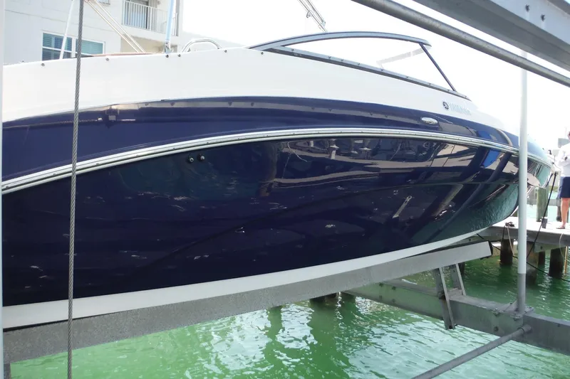 Slide: The Image of 2011 Yamaha Boats 242 Limited on lift, dockside view. - 47
