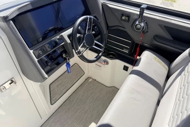 Slide: The Image of 2023 Cobalt A29 boat cockpit with steering wheel, controls, and navigation screens. - 17