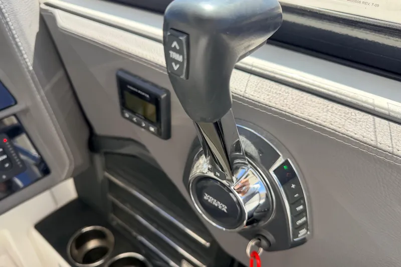 Slide: The Image of Throttle control of 2023 Cobalt A29 boat with trim adjustment buttons. - 20