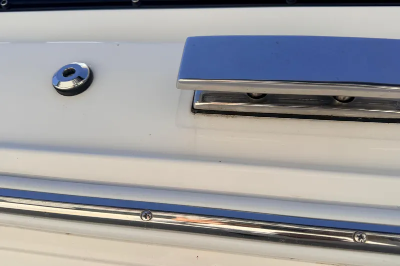 Slide: The Image of Close-up of 2023 Cobalt A29 boat's sleek chrome fittings and white surface. - 23