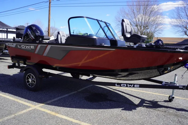 Slide: The Image of 2026 Lowe Fishing Machine 1675 WT boat, red exterior, parked on trailer in sunny lot. - 11