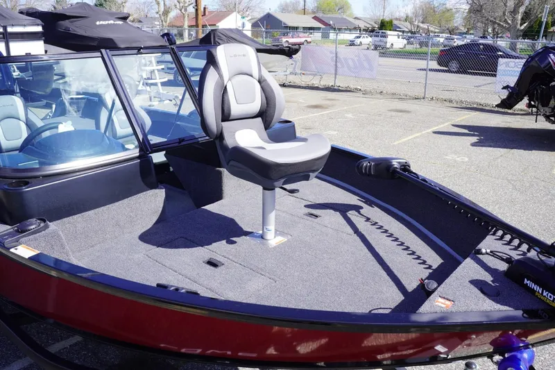 Slide: The Image of 2026 Lowe Fishing Machine 1675 WT boat with seating and trolling motor in a parking lot. - 12