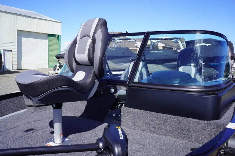 Slide: The Image of 2026 Lowe Fishing Machine 1675 WT boat seat and windshield in a marina setting. - 15