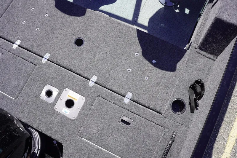 Slide: The Image of 2026 Lowe Fishing Machine 1675 WT boat deck with storage compartments and fishing rod holders. - 24