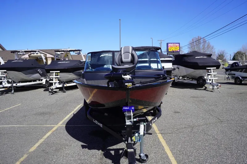 Slide: The Image of 2026 Lowe Fishing Machine 1675 WT boat displayed in a parking lot with other boats. - 3