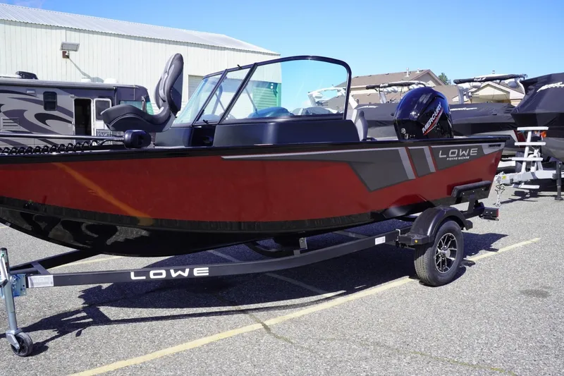 Slide: The Image of 2026 Lowe Fishing Machine 1675 WT boat on trailer, red and black design, parked outdoors. - 5