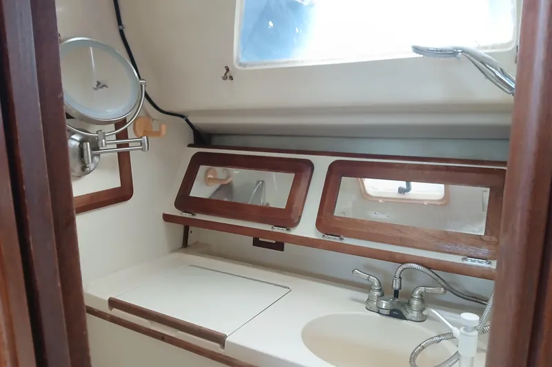 Slide: The Image of Interior of a 1994 Hunter 30 sailboat bathroom with sink and mirrors. - 12