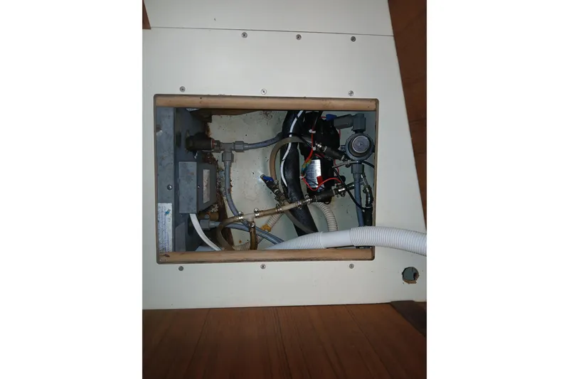 Slide: The Image of Interior view of a 1994 Hunter 30 boat's plumbing system with hoses and fittings. - 17