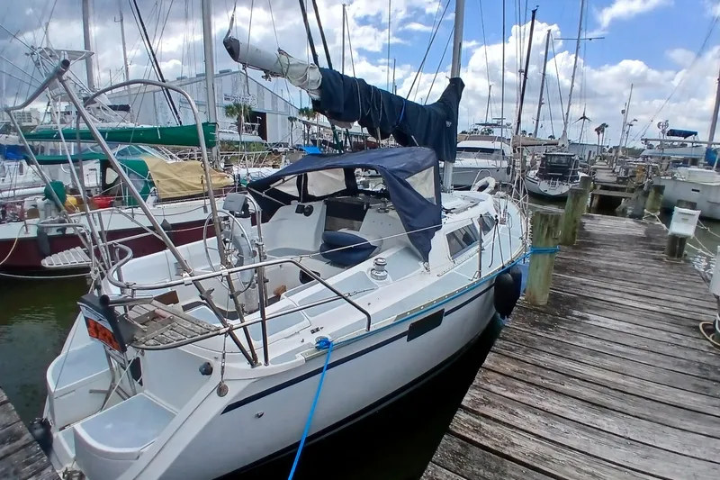 Slide: The Image of Sailboat docked at marina, 1994 Hunter 30 model, with blue cover and clear skies. - 23